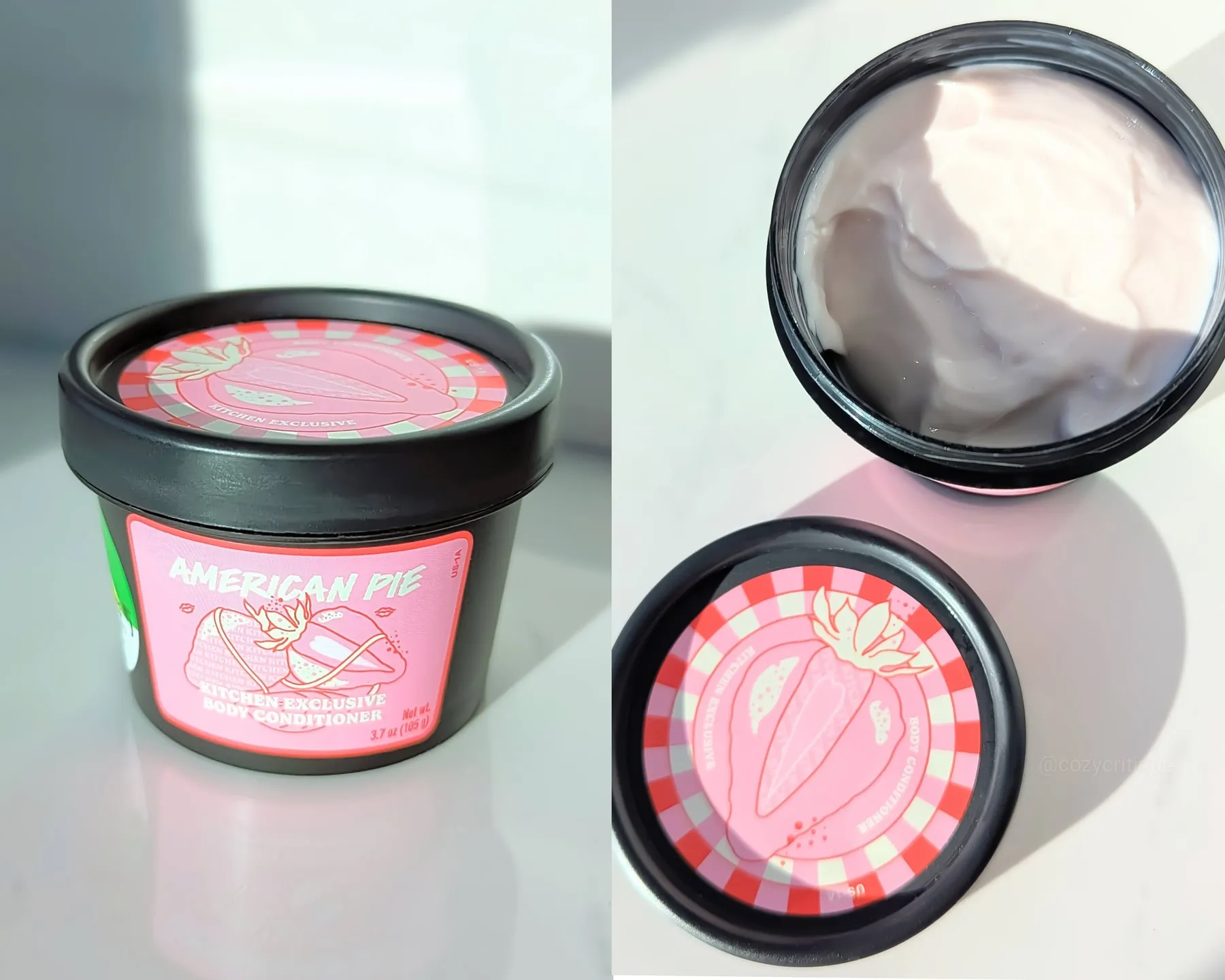 Black container labeled "American Pie" with a strawberry design. Open lid reveals creamy body conditioner. Bright lighting on a white surface.
