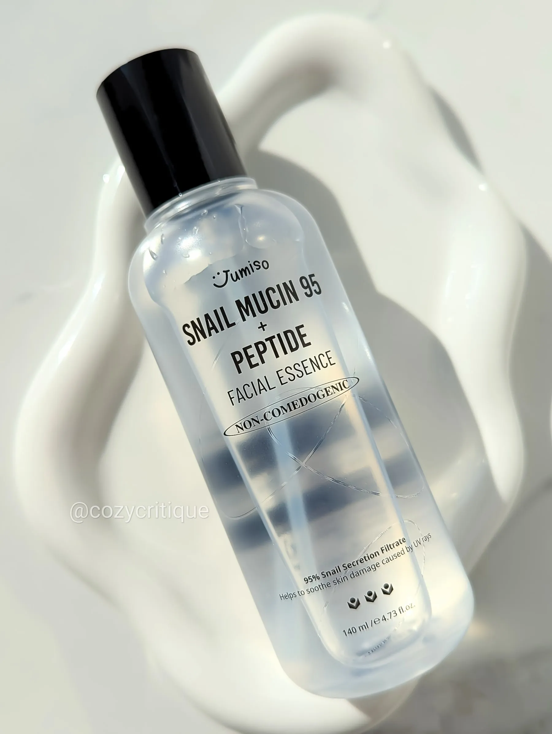 A skincare bottle laying on a white tray.