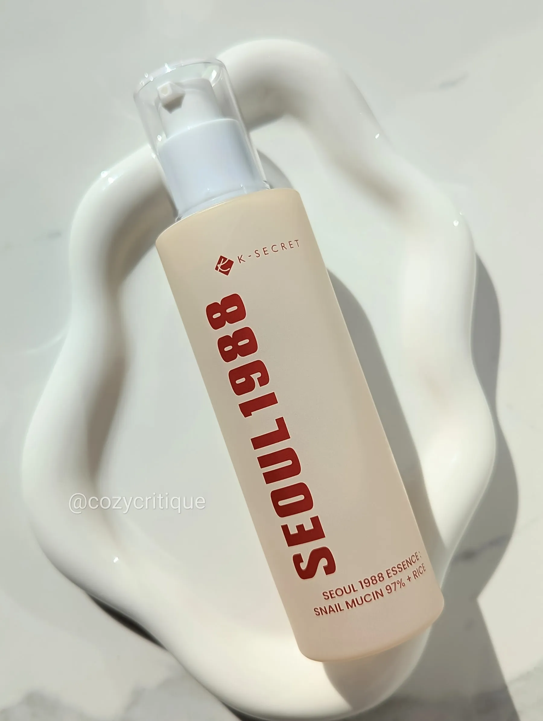 A skincare bottle laying on a white tray.