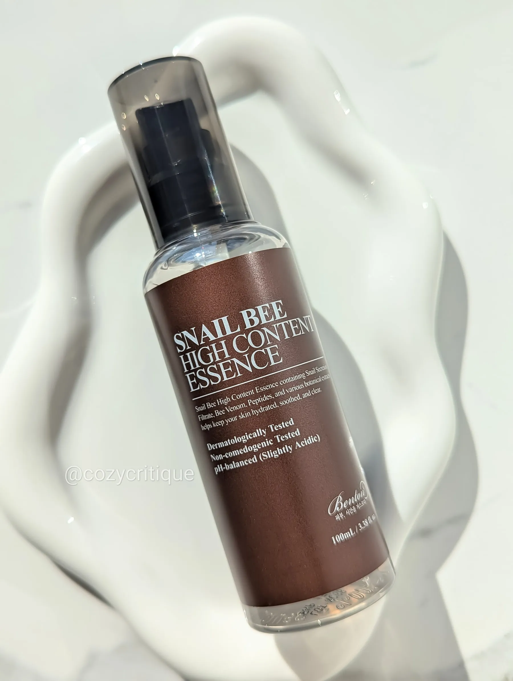 A skincare bottle laying on a white tray.
