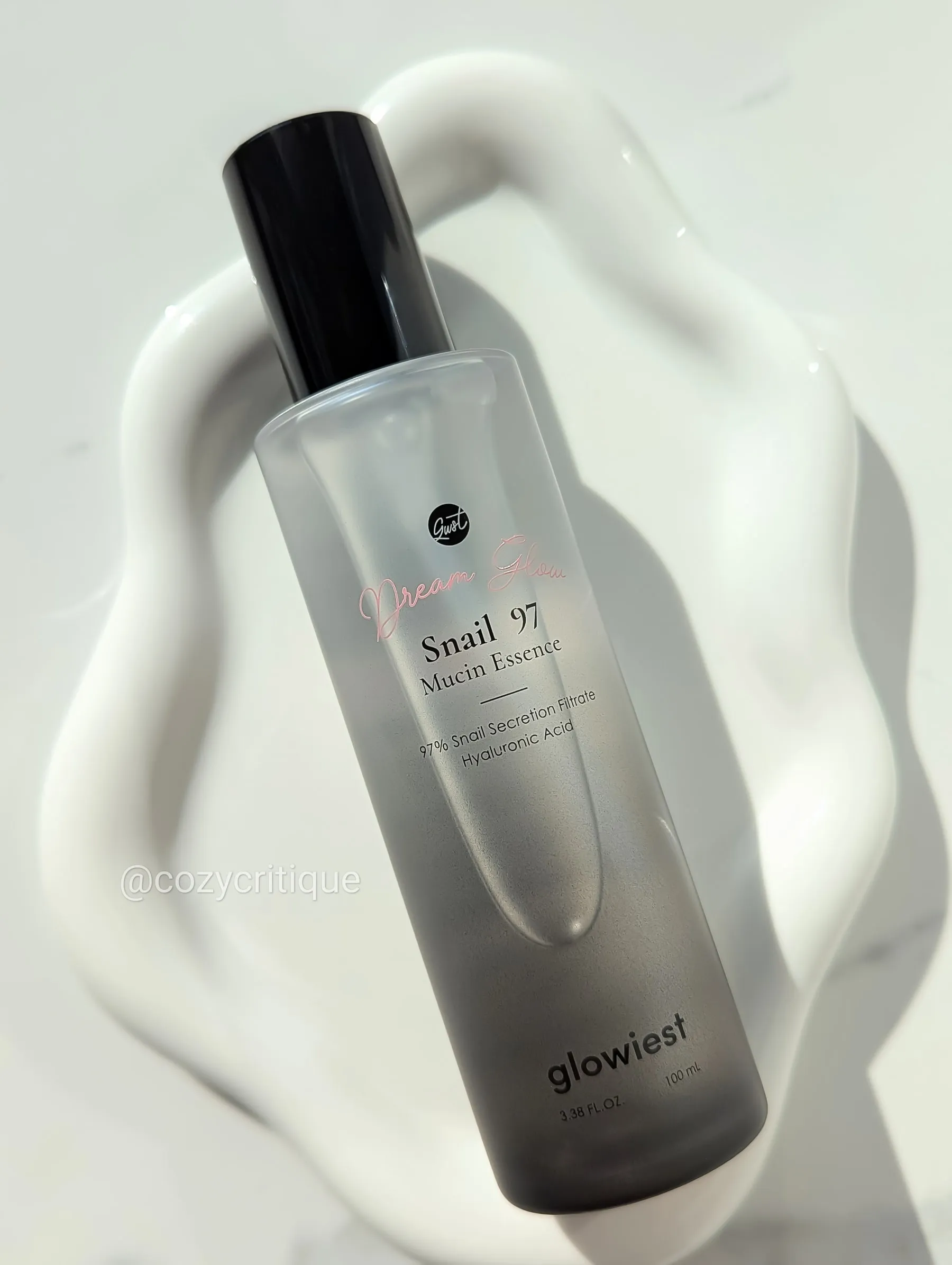A skincare bottle laying on a white tray.