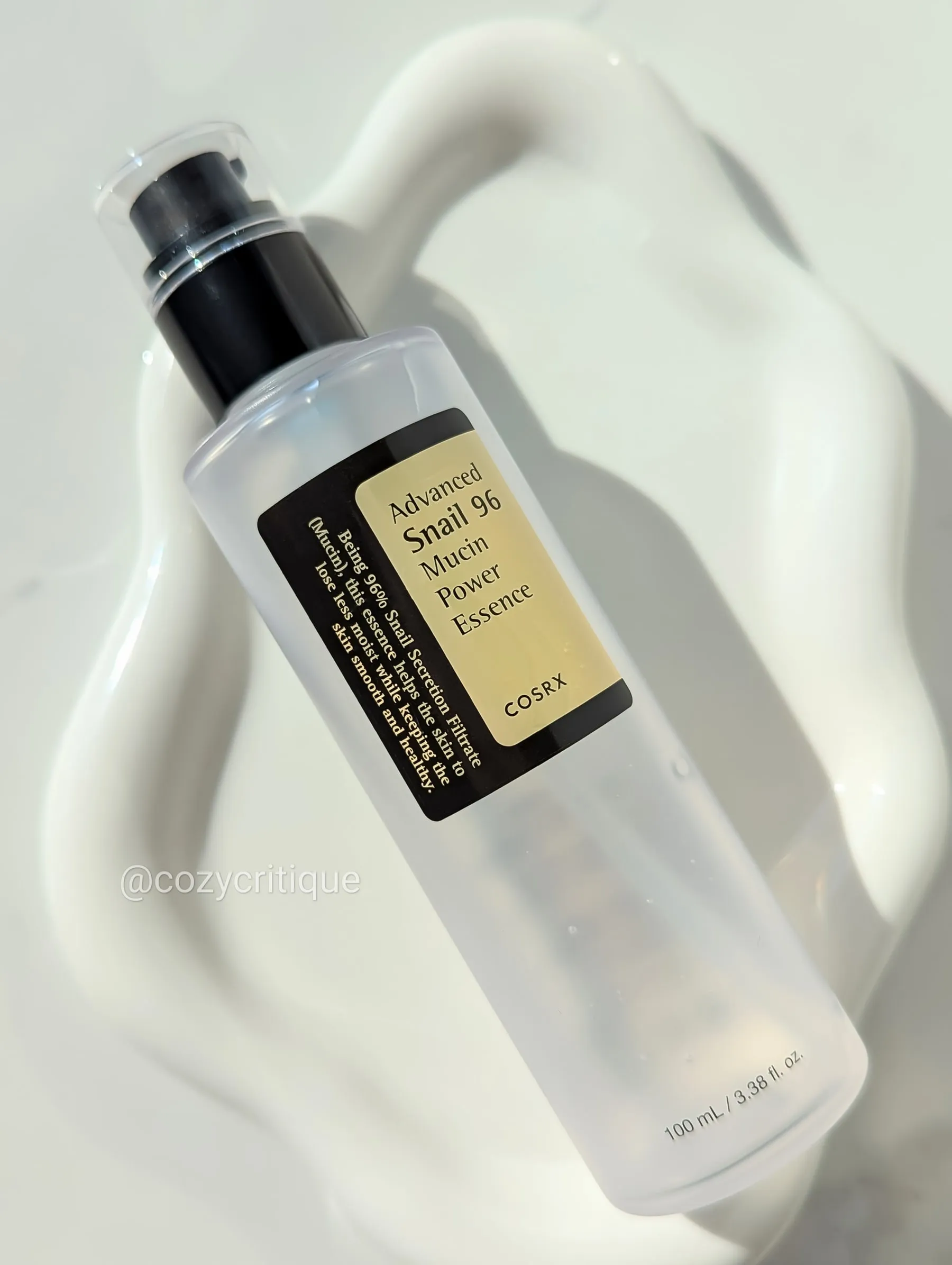 A skincare bottle laying on a white tray.