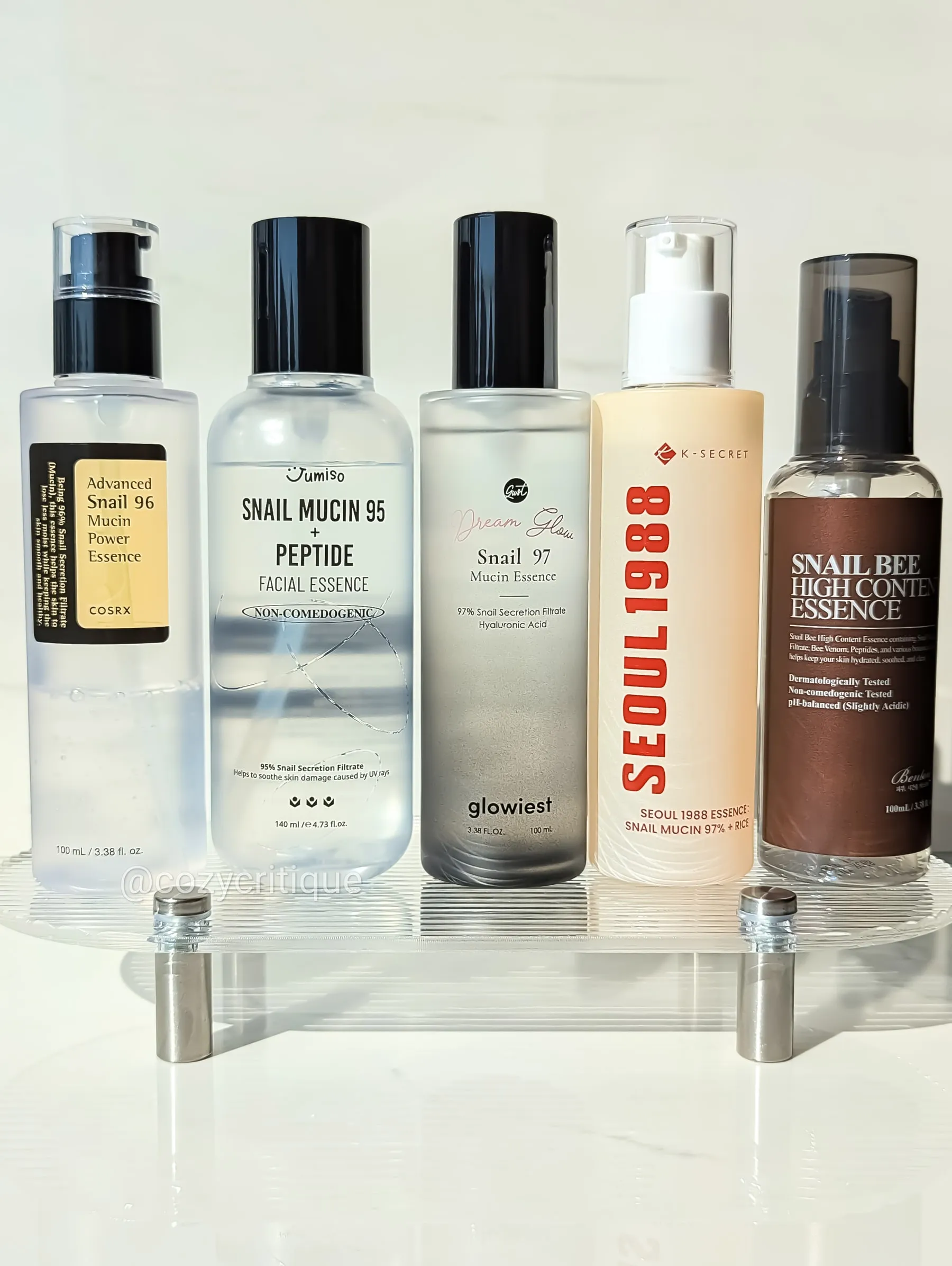 Five Korean snail mucin essence bottles arranged for comparison