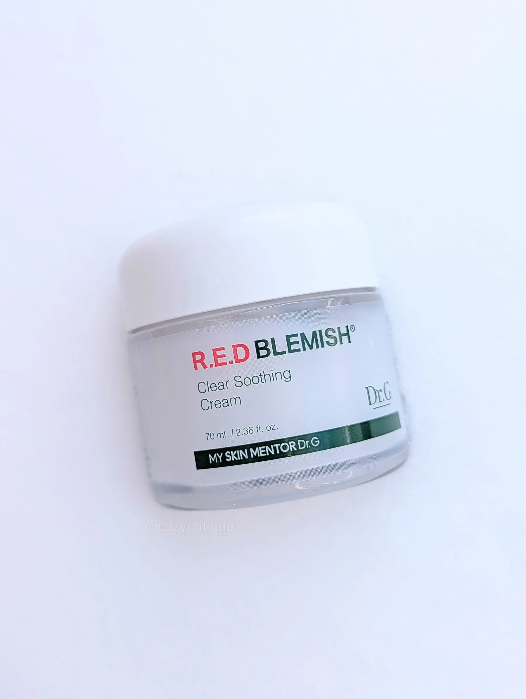 A jar of Dr.G R.E.D Blemish Clear Soothing Cream on a snowy background. The jar is white with red and green text.