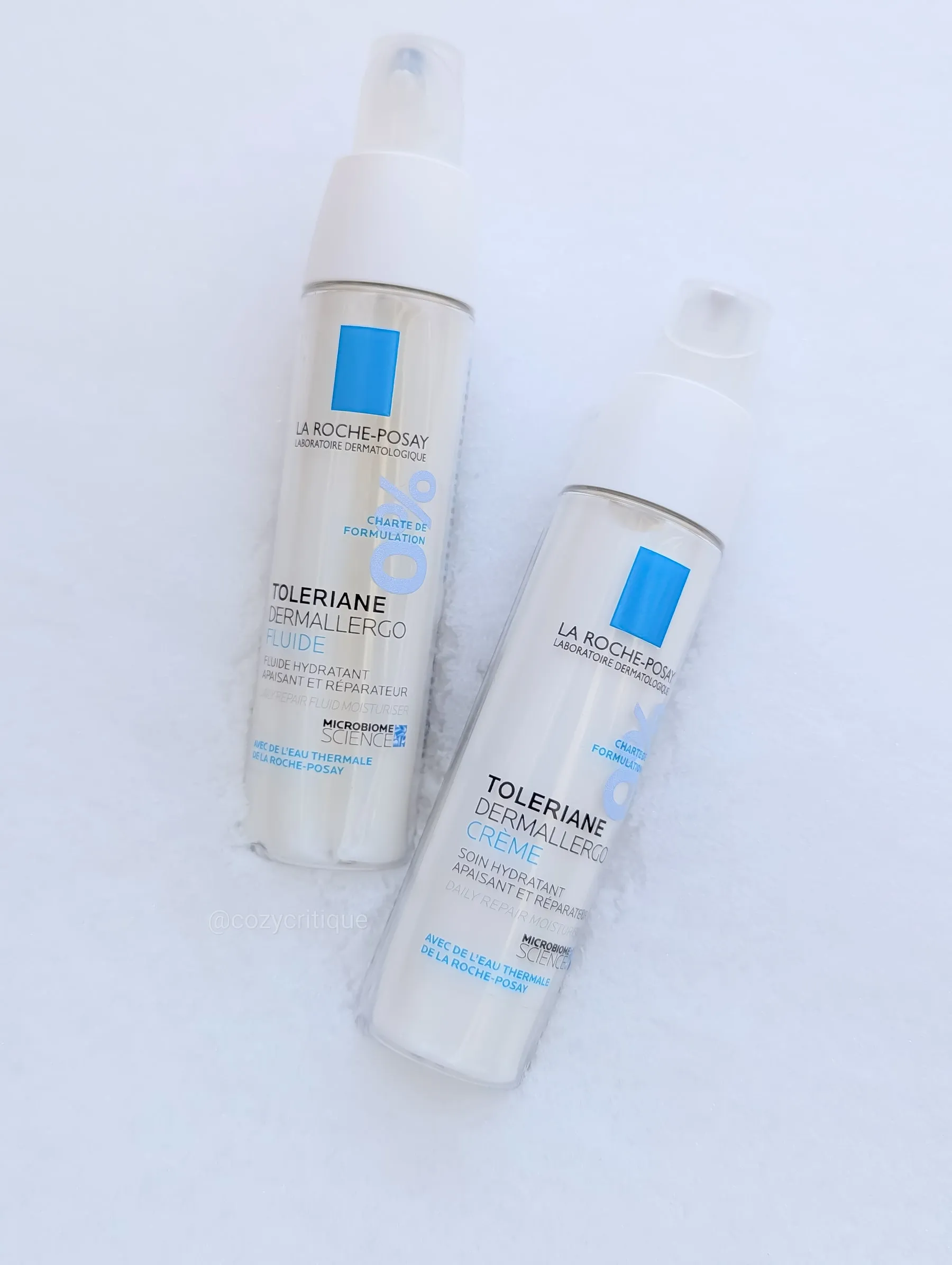 Two La Roche-Posay Toleriane Dermallergo products on snow. White bottles with blue accents, labeled Fluid and Creme. Calm, pristine setting.