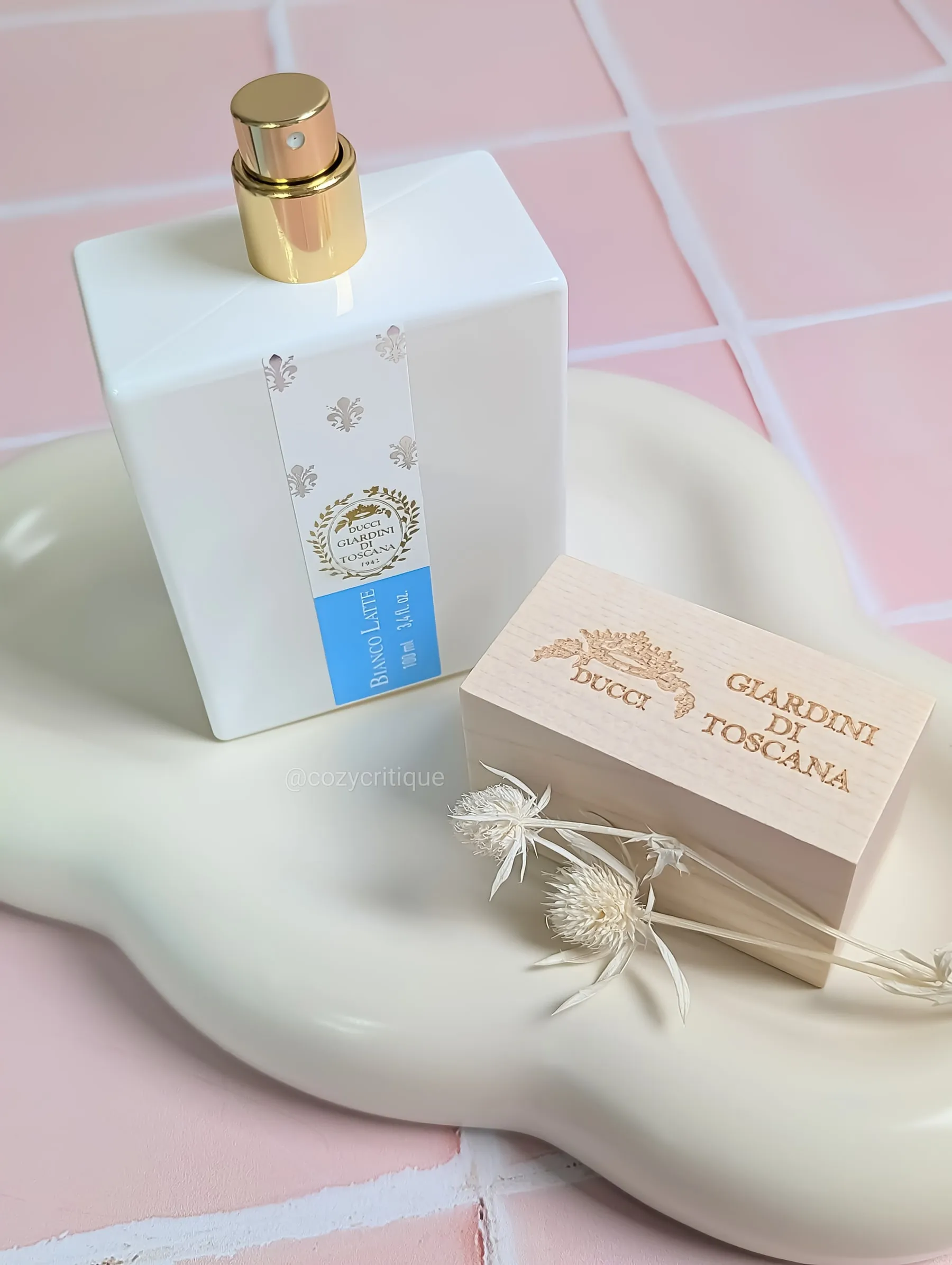 A bottle of Bianco Latte perfume standing on a tray with the lid off